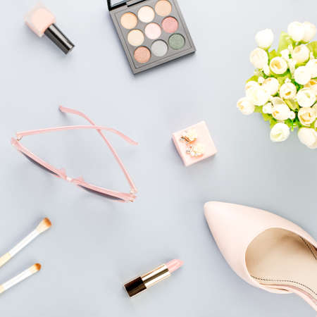 Fashion blogger workspace flat lay with pumps, cosmetics, purse, planner book and flowers.の写真素材
