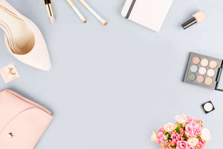 Fashion blogger workspace flat lay with pumps, cosmetics, purse, planner book and flowers.の写真素材