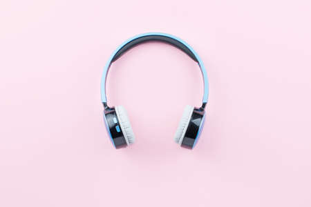 Blue wireless headphones close up on pastel pink background. Flat lay, top viewの写真素材