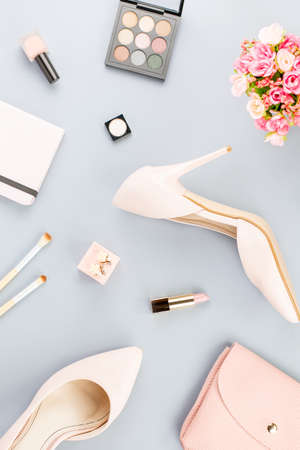 Fashion blogger workspace flat lay with pumps, cosmetics, purse, planner book and flowers.の写真素材