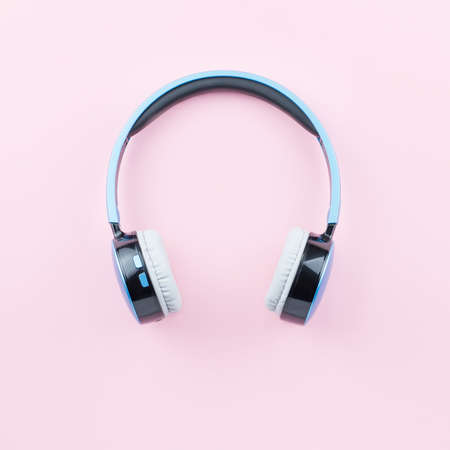 Blue wireless headphones close up on pastel pink background. Flat lay, top viewの写真素材