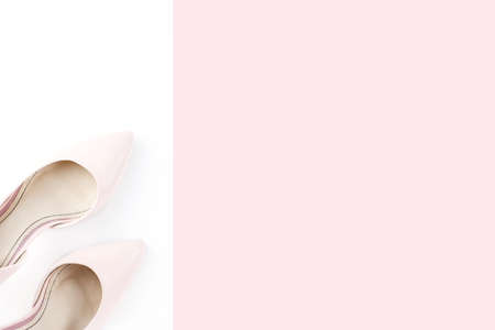 Woman pale pink pumps on pink and white background. Top view, copy space, minimal background. Fashion conceptの写真素材