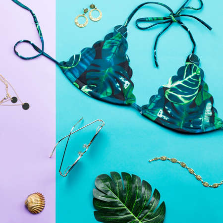 Tropical bikini swimsuit, beach fashion. Traveler woman accessories flat lay with swimwear, palm leaves.の写真素材