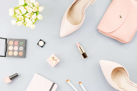 Fashion blogger workspace flat lay with pumps, cosmetics, purse, planner book and flowers.の写真素材
