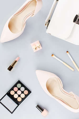 Fashion blogger workspace flat lay with pumps, cosmetics, purse, planner book and flowers.の写真素材