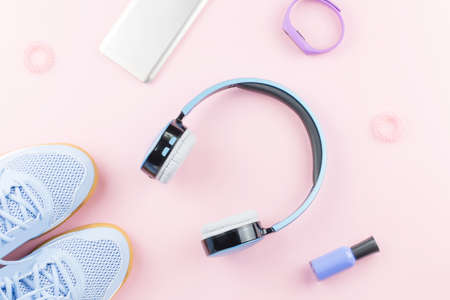 Woman sneakers, headphones, fitness tracker and smartphone on pastel pink background. Sport fashion concept. Flat layの写真素材
