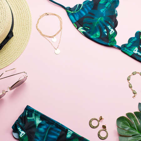 Tropical bikini swimsuit, beach fashion. Traveler woman accessories flat lay with swimwear, palm leaves.の写真素材