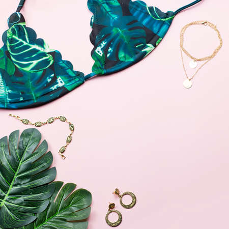 Tropical bikini swimsuit, beach fashion. Traveler woman accessories flat lay with swimwear, palm leaves.の写真素材