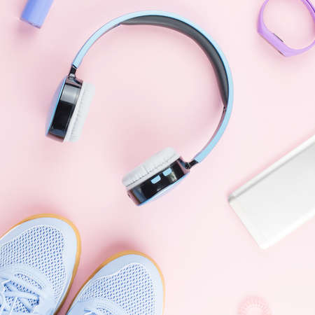 Woman sneakers, headphones, fitness tracker and smartphone on pastel pink background. Sport fashion concept. Flat layの写真素材