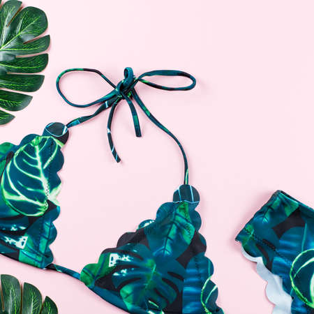 Tropical bikini swimsuit, beach fashion. Traveler woman accessories flat lay with swimwear, palm leaves.の写真素材