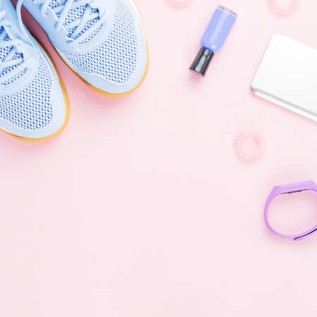 Woman sneakers, fitness tracker and smartphone on pastel pink background. Sport fashion concept. Flat layの写真素材