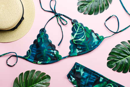 Tropical bikini swimsuit, beach fashion. Traveler woman accessories flat lay with swimwear, palm leaves.の写真素材