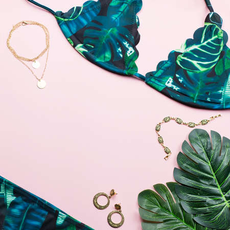 Tropical bikini swimsuit, beach fashion. Traveler woman accessories flat lay with swimwear, palm leaves.の写真素材