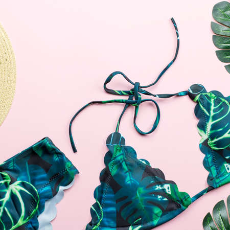 Tropical bikini swimsuit, beach fashion. Traveler woman accessories flat lay with swimwear, palm leaves.の写真素材