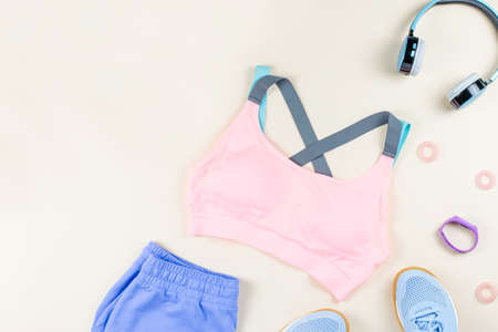 Woman sport clothes, sneakers, headphones and fitness tracker on neutral background. Sport fashion concept. Flat lay, top viewの写真素材