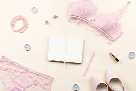 Fashion blogger workspace with woman elegant pink lace bra and panties, pumps and note book. Stylish lingerie flat lay. Top viewの写真素材