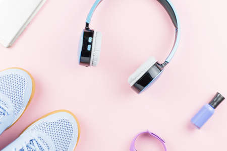 Woman sneakers, headphones, fitness tracker and smartphone on pastel pink background. Sport fashion concept. Flat lay, top viewの写真素材