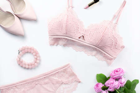 Woman elegant pink lace bra and panties, flowers, jewelry. Stylish lingerie flat lay. Underwear fashion concept. Top viewの写真素材