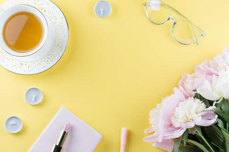 Flat lay home office desk. Feminine workspace with diary, peony flowers, cosmetics, green tea. Fashion blogger concept. Top viewの写真素材