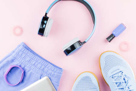 Woman sneakers, headphones, fitness tracker and smartphone on pastel pink background. Sport fashion concept. Flat lay, top viewの写真素材