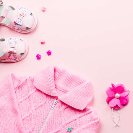 Little girl clothes collection flat lay with pink cardigan, sandals on pink background. Top viewの写真素材