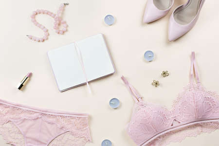 Fashion blogger workspace with woman elegant pink lace bra and panties, pumps and note book. Stylish lingerie flat lay. Top viewの写真素材