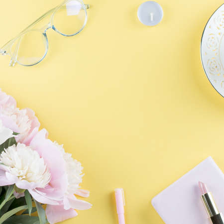 Flat lay home office desk. Feminine workspace with diary, peony flowers, cosmetics, green tea. Fashion blogger concept. Top viewの写真素材