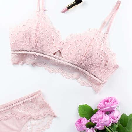 Woman elegant pink lace bra and panties, flowers, jewelry. Stylish lingerie flat lay. Underwear fashion concept. Top viewの写真素材