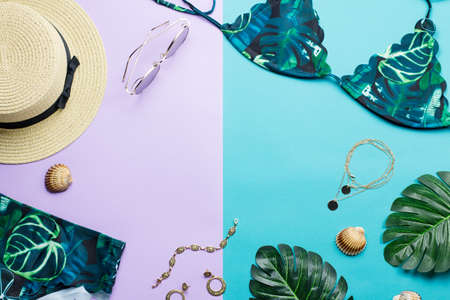 Tropical bikini swimsuit and woman accessories, beach fashion. Traveler accessories flat lay with female swimwear, palm leaves. top viewの写真素材