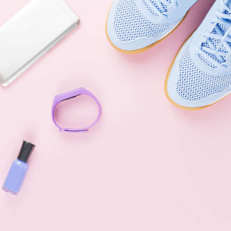 Woman sneakers, fitness tracker and smartphone on pastel pink background. Sport fashion concept. Flat lay, top viewの写真素材