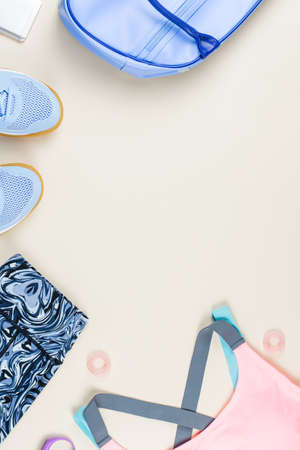 Woman sport clothes, sneakers, headphones and fitness tracker on neutral background. Sport fashion concept. Flat lay, top viewの写真素材