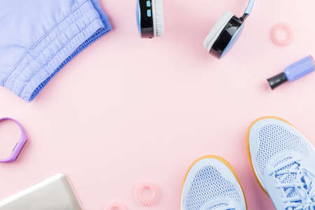 Woman sneakers, headphones, fitness tracker and running clothes on pastel pink background. Sport fashion concept. Flat lay, top viewの写真素材