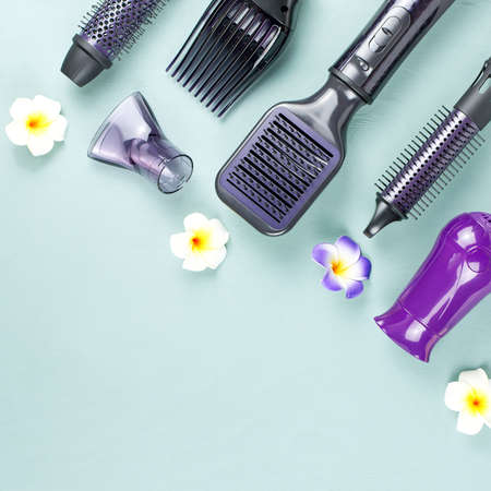 Hairdressing tools with flowers on blue wooden backgroundの写真素材