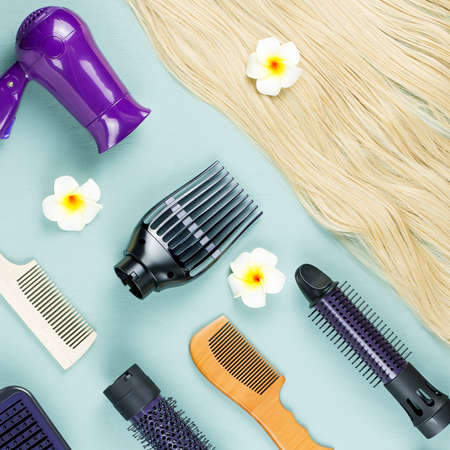 Hairdressing tools and hair extensions on blue wooden background. Top viewの写真素材