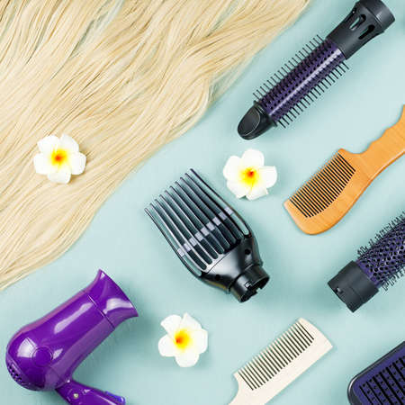 Hairdressing tools and hair extensions on blue wooden background. Top viewの写真素材