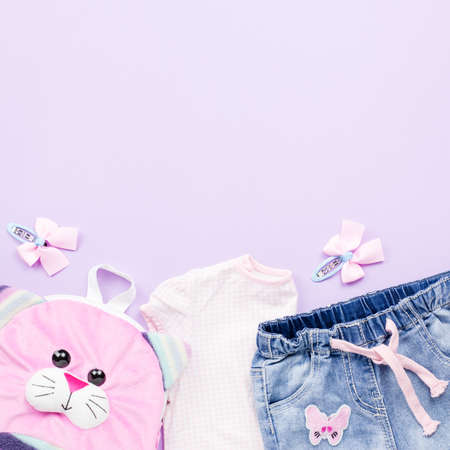 Little girl clothes collection flat lay with t-shirt, jeans, sandals, backpack on pastel background.の写真素材