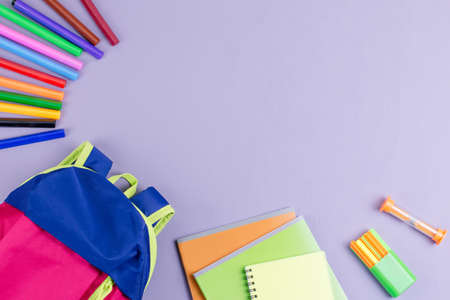School concept flat lay. Kid backpack, notebook, markers on wooden desktopの写真素材