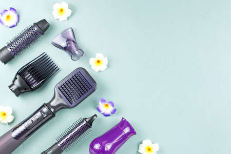 Hairdressing tools with flowers on blue wooden backgroundの写真素材