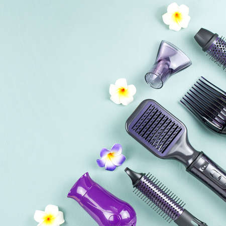 Hairdressing tools with flowers on blue wooden backgroundの写真素材