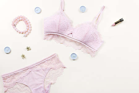 Fashion blogger workspace with woman elegant pink lace bra and panties, cosmetics. Stylish lingerie flat lay.の写真素材