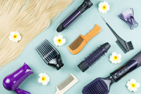 Hairdressing tools and hair extensions on blue wooden background. Top viewの写真素材