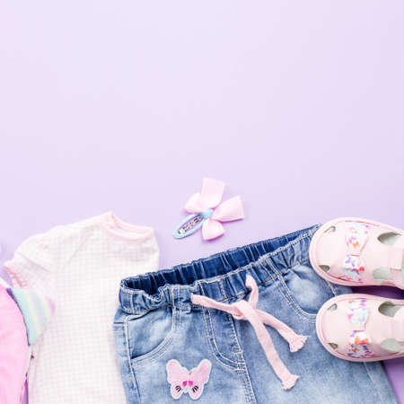 Little girl clothes collection flat lay with t-shirt, jeans, sandals, backpack on pastel background.の写真素材