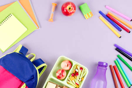 School concept flat lay. Kid backpack, lunchbox, water bottle, notebook, markers on wooden desktopの写真素材