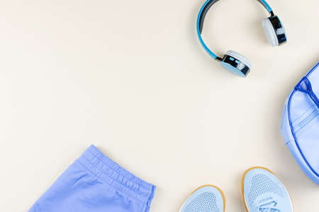 Woman sport clothes, sneakers, headphones and fitness tracker on neutral background. Sport fashion concept. Flat layの写真素材