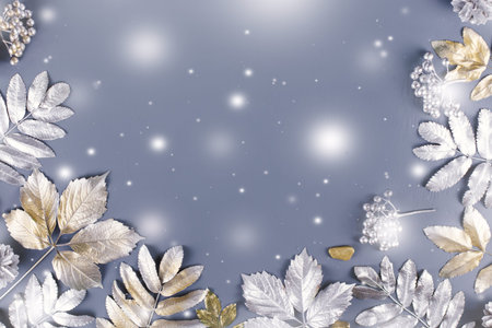 Winter concept flat lay with golden and silver leaves, copy space. Top view