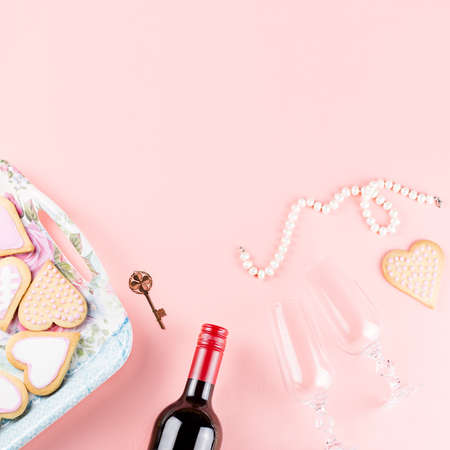 Valentine's day cookies, wine glasses and wine on pink background. Top viewの写真素材