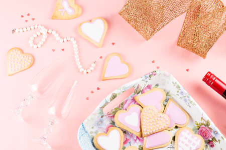 Valentine's day cookies, wine glasses and wine on pink background. Top viewの写真素材