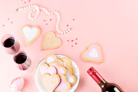 Valentines day cookies, wine glasses and wine on pink background.の写真素材