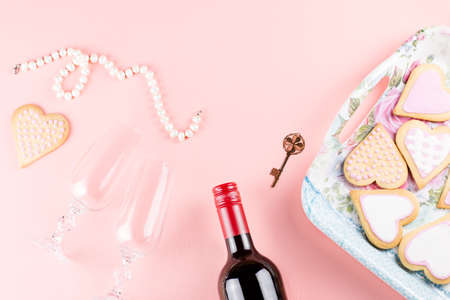 Valentine's day cookies, wine glasses and wine on pink background. Top viewの写真素材