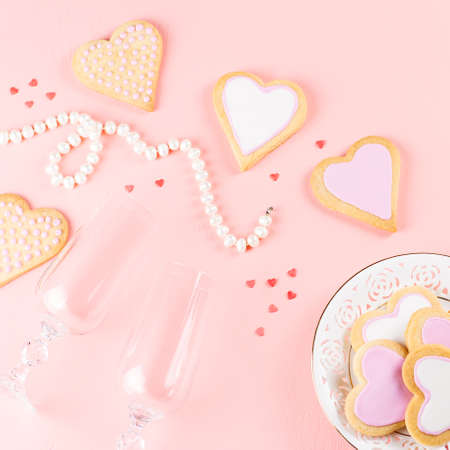 Valentines day cookies, wine glasses and wine on pink background.の写真素材